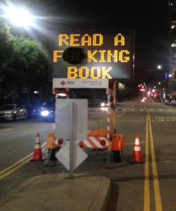 Electronic road sign reads: "Read a fucking book"